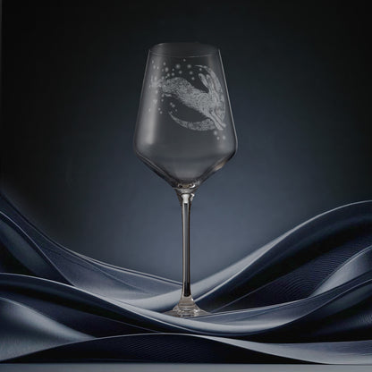 Engraved wine glass featuring a hare leaping across a crescent moon of snowflakes