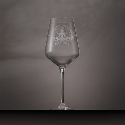 Engraved wine glass featuring Sukhasana yoga pose seated in a lotus flower with mandala-style circles and dotted diamond design