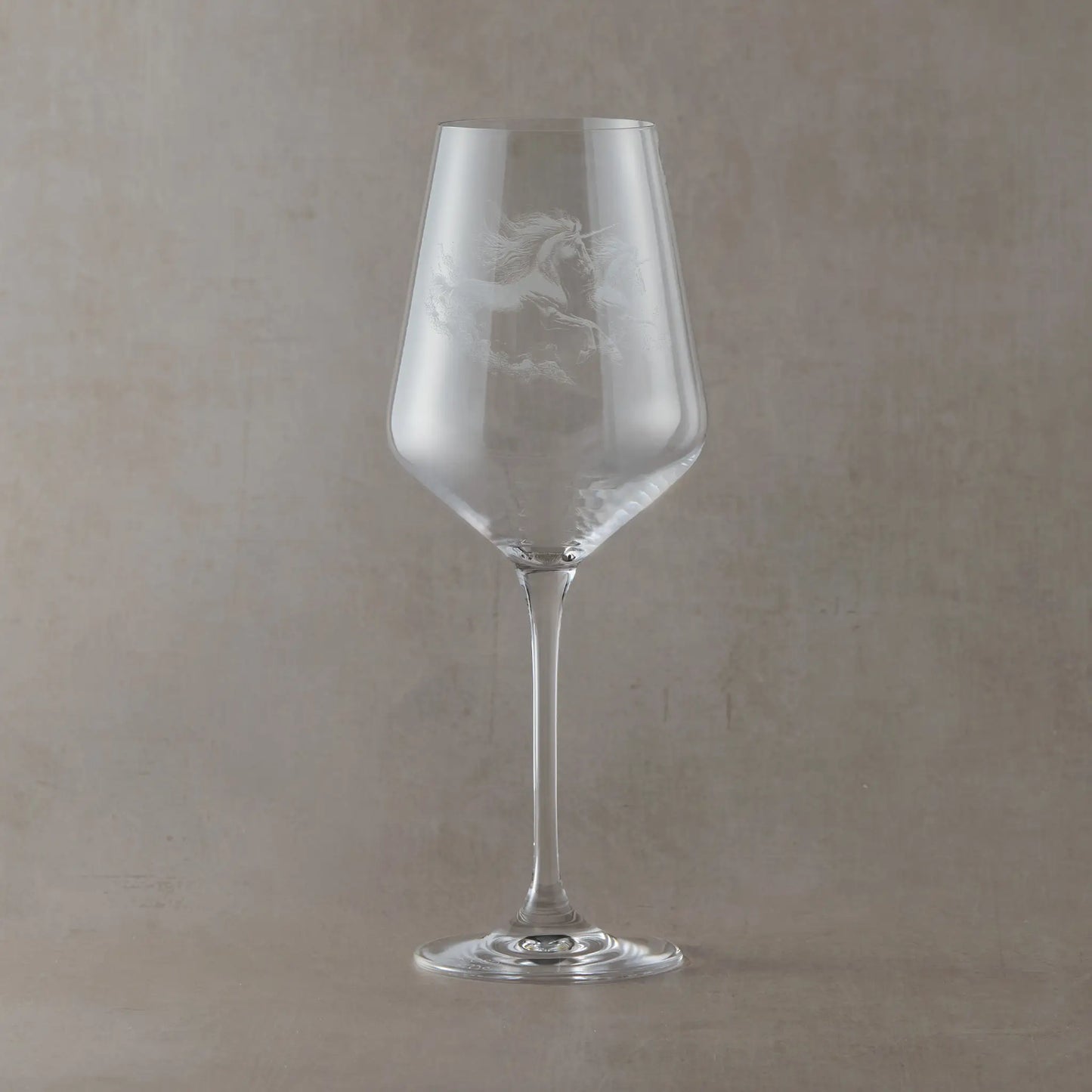 Engraved wine glass with an  illustration of two unicorns galloping 