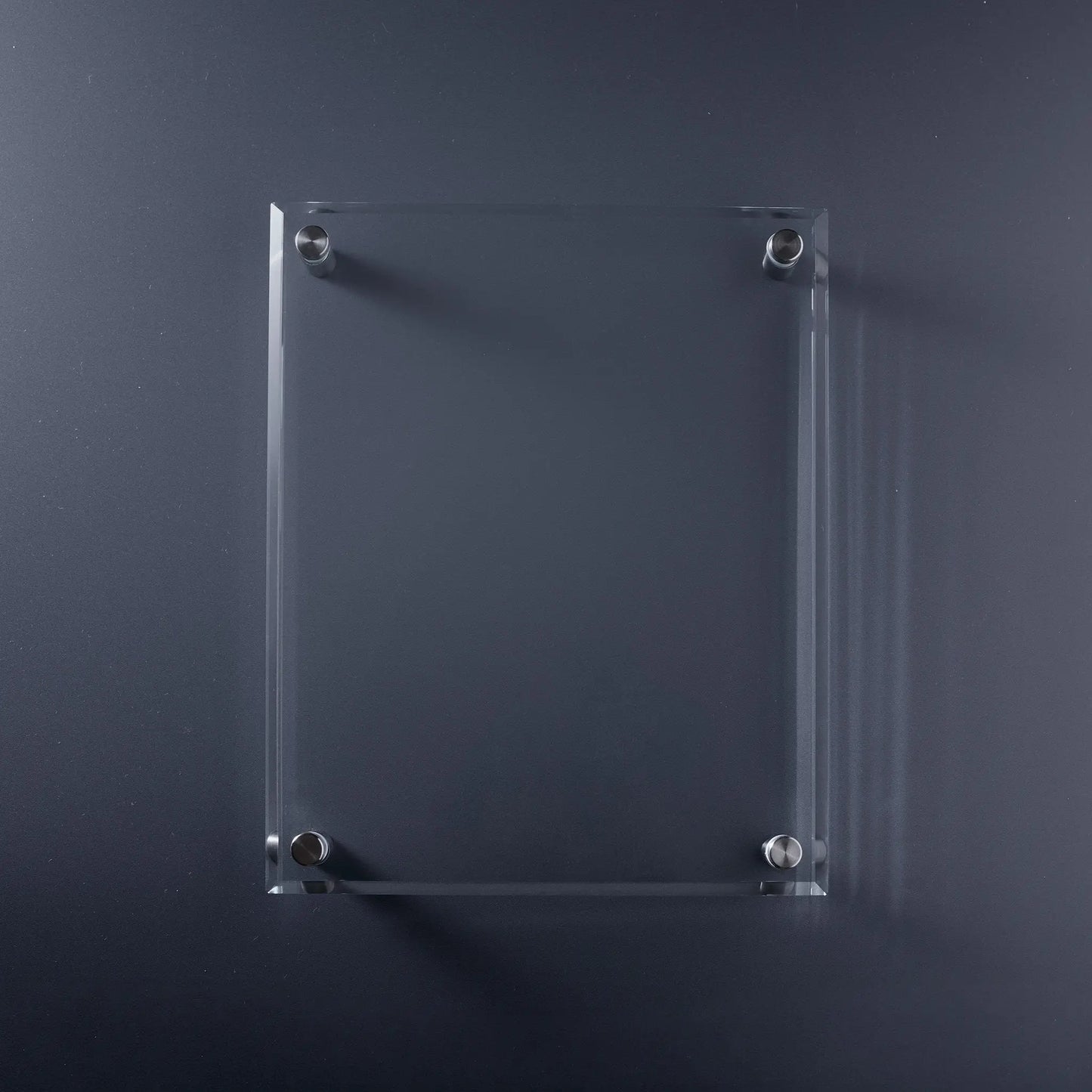 A clear rectangular glass display plaque with bevelled edges and four silver metal mounting screws.