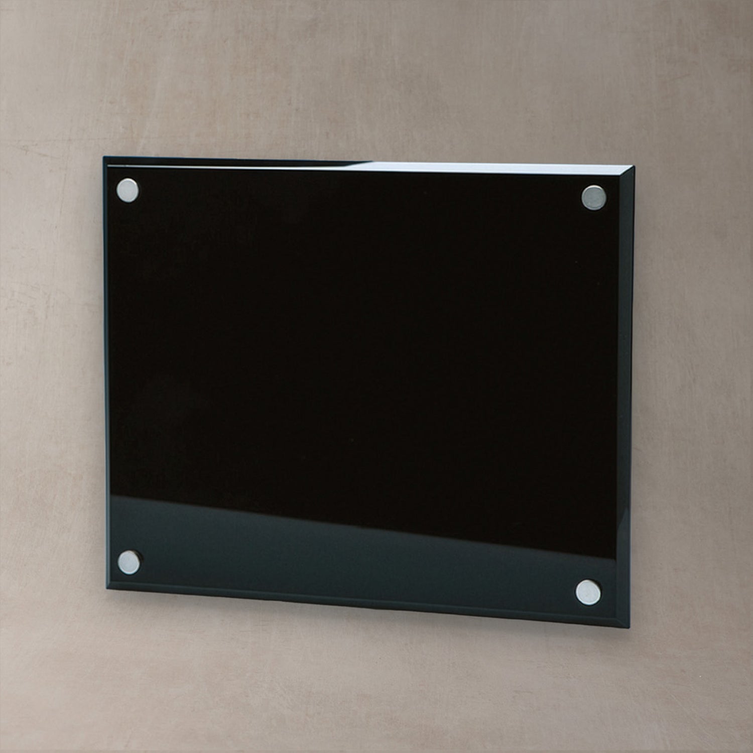 A rectangular glossy black glass plaque and four silver metal mounting dots, mounted on a textured beige wall.
