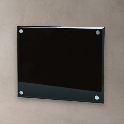 A rectangular glossy black glass plaque and four silver metal mounting dots, mounted on a textured beige wall.