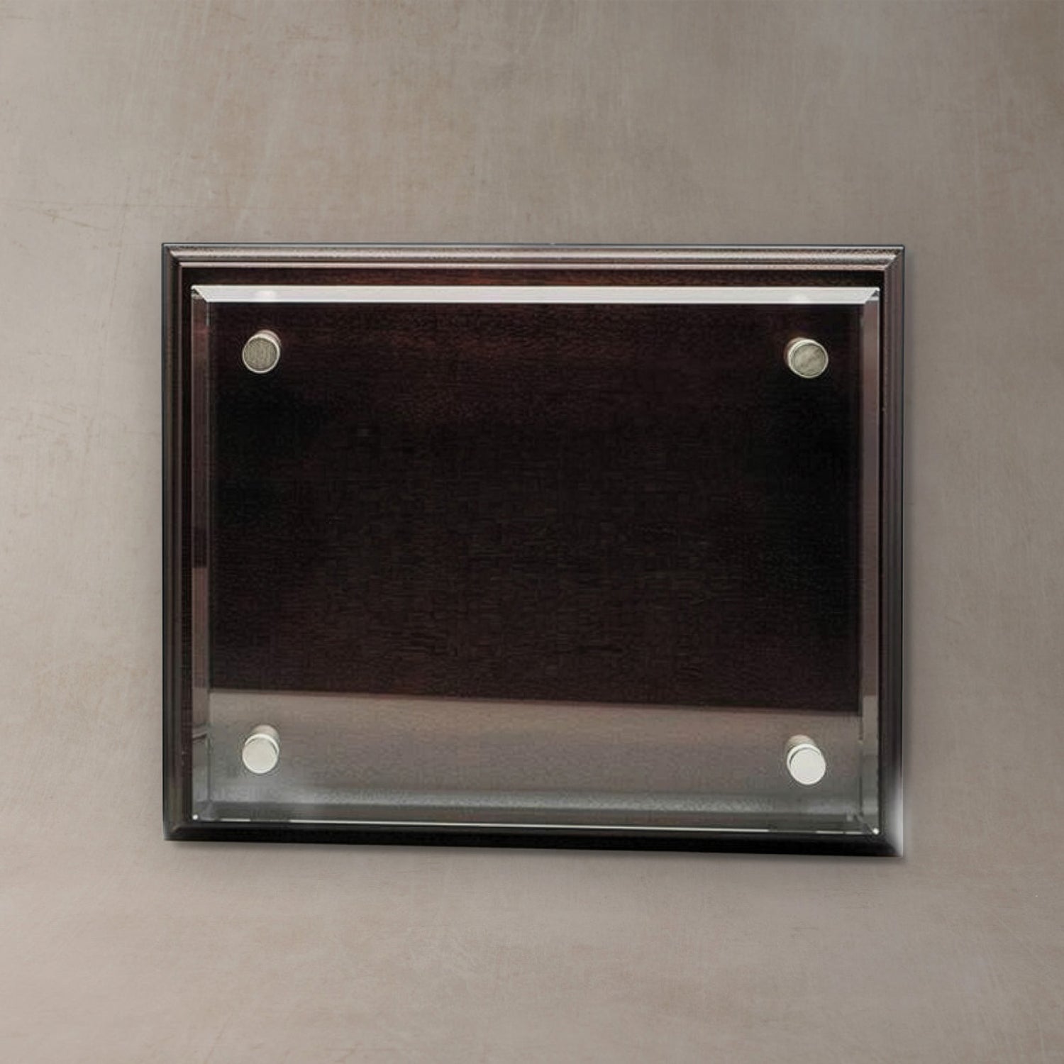 A rectangular wall-mounted display plaque with a dark wood frame and four silver wall anchors, shown against a textured gray wall.