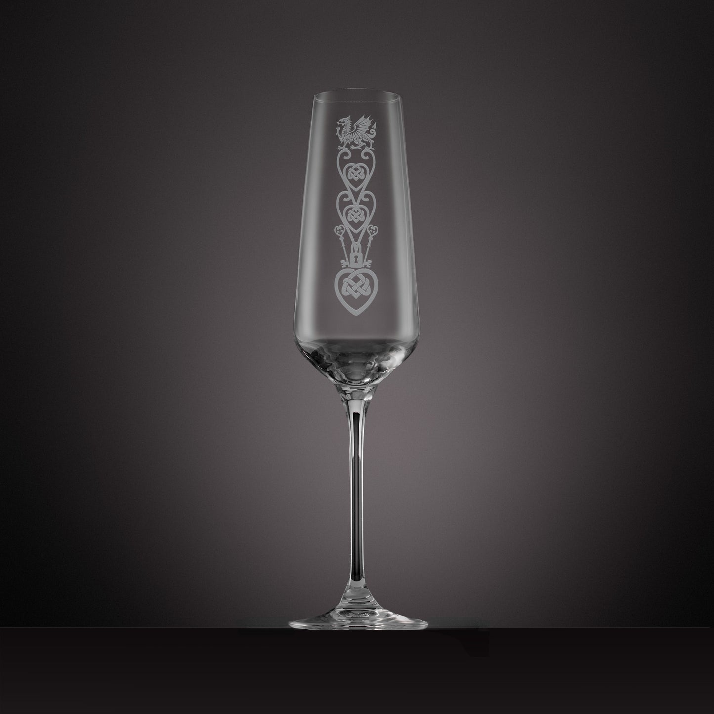 Engraved glass champagne flute featuring a celtic knotwork lovespoon and Welsh Dragon design