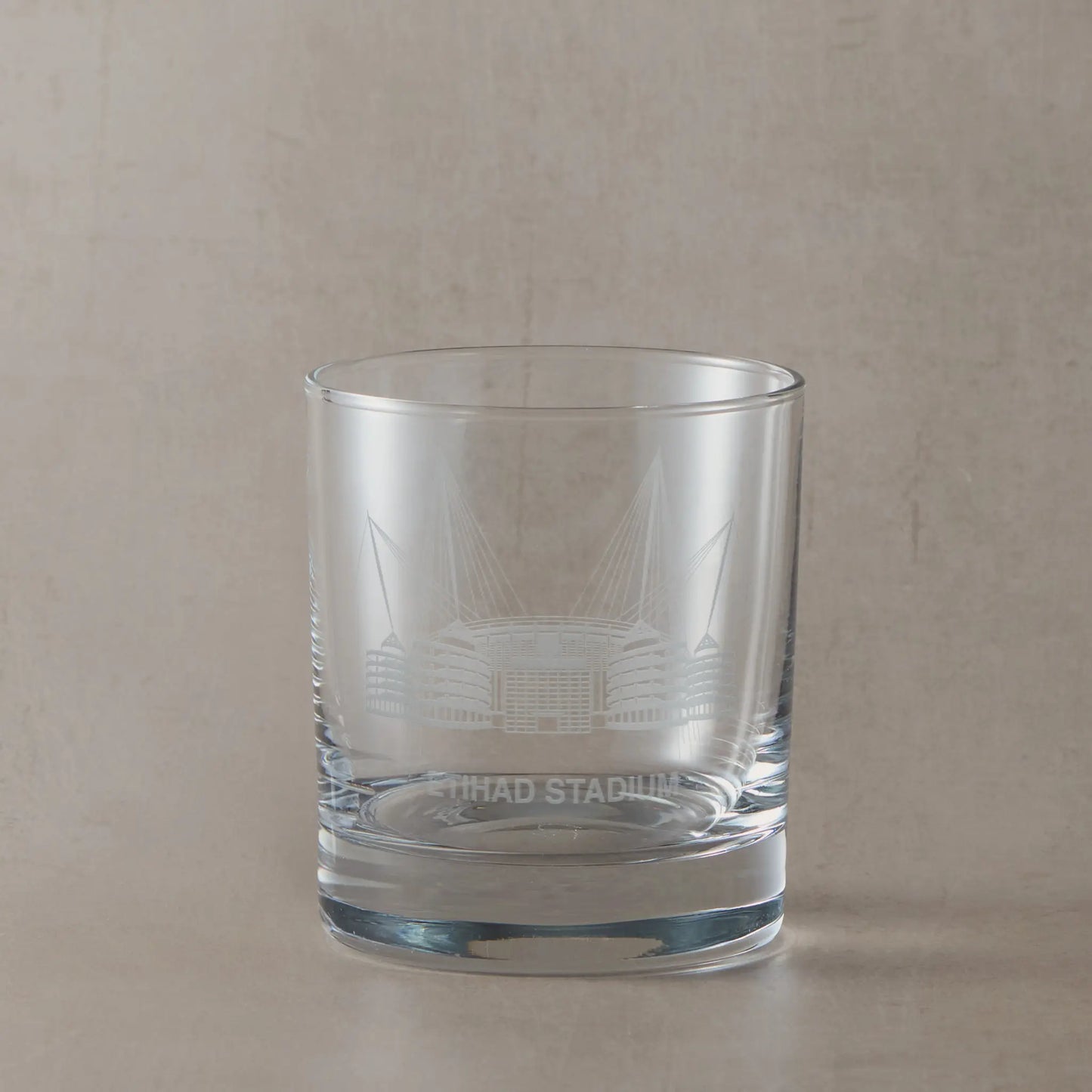Manchester whisky tumbler engraved with a line-art interpretation of the Etihad Stadium, with space for personalisation.