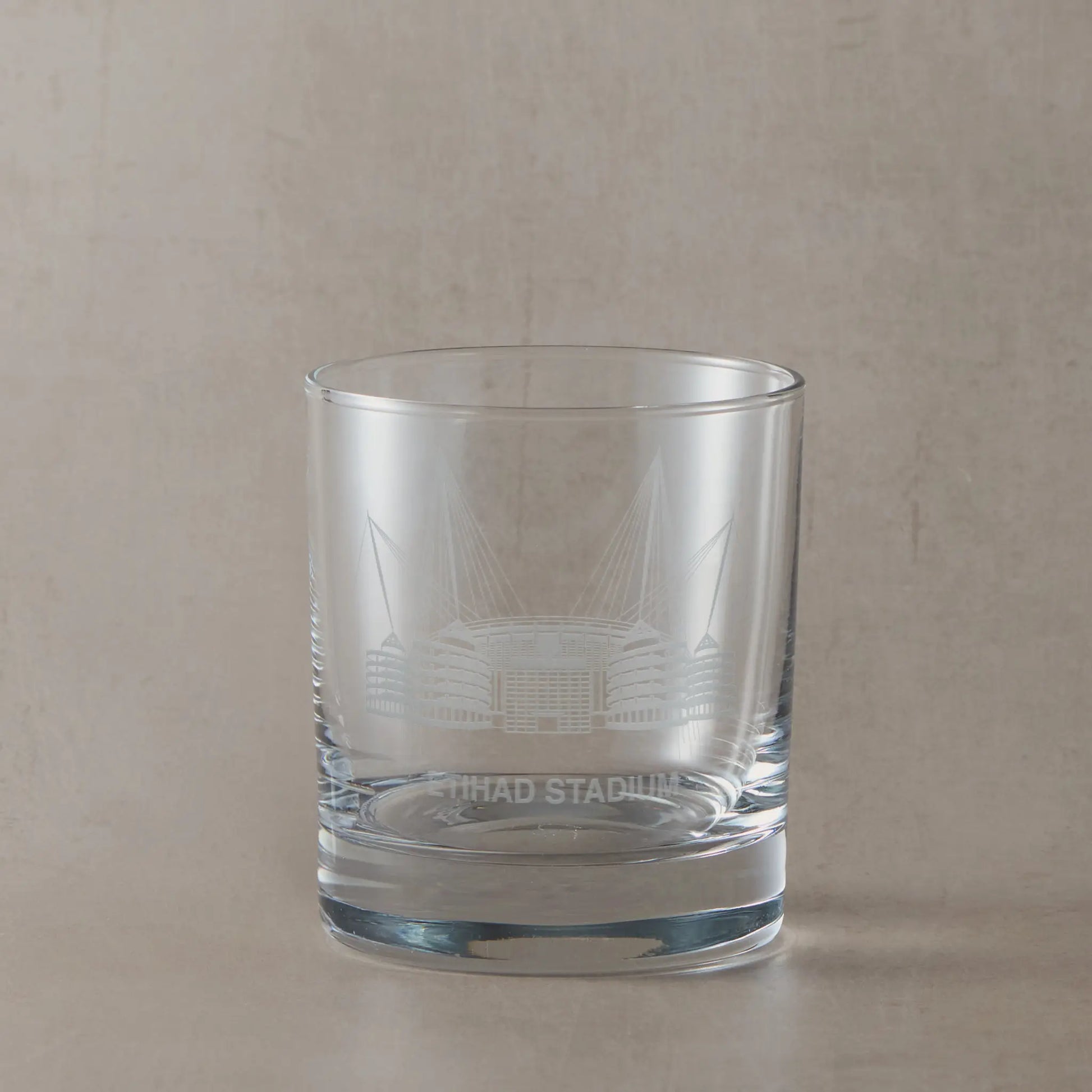 Manchester whisky tumbler engraved with a line-art interpretation of the Etihad Stadium, with space for personalisation.