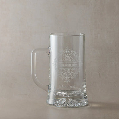 Father of the bride engraved glass tankard personalised with names and date, ona plae background.