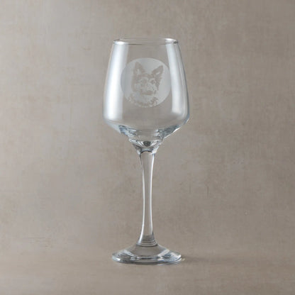 Wine glass engraved with a portrait of a German Shepherd shown against a beige background.