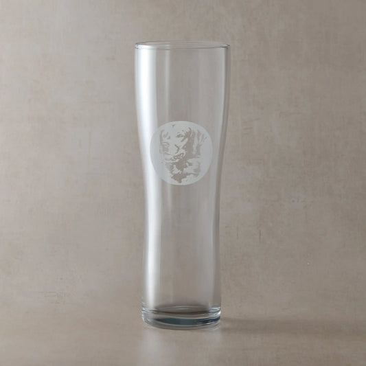 Pint Glass with engraved with portrait of a golden retriever in circular frame , photographed in a pale background