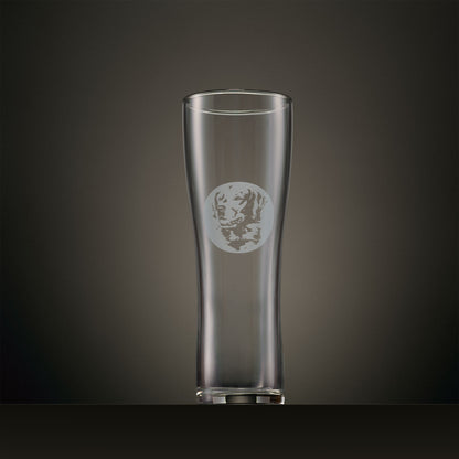 Engraved pint glass featuring a Golden Retriever portrait set within a circular design, photographed on a dark studio background