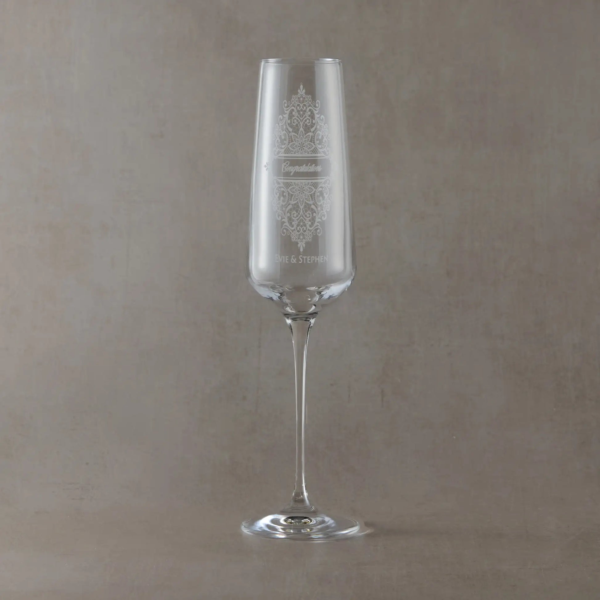 Champagne flute engraved with names and congratulations enclosed in a Guipure lace design.