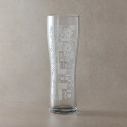 Personalised beer glass engraved with guitar amp circuit board design, shown on a beige background.