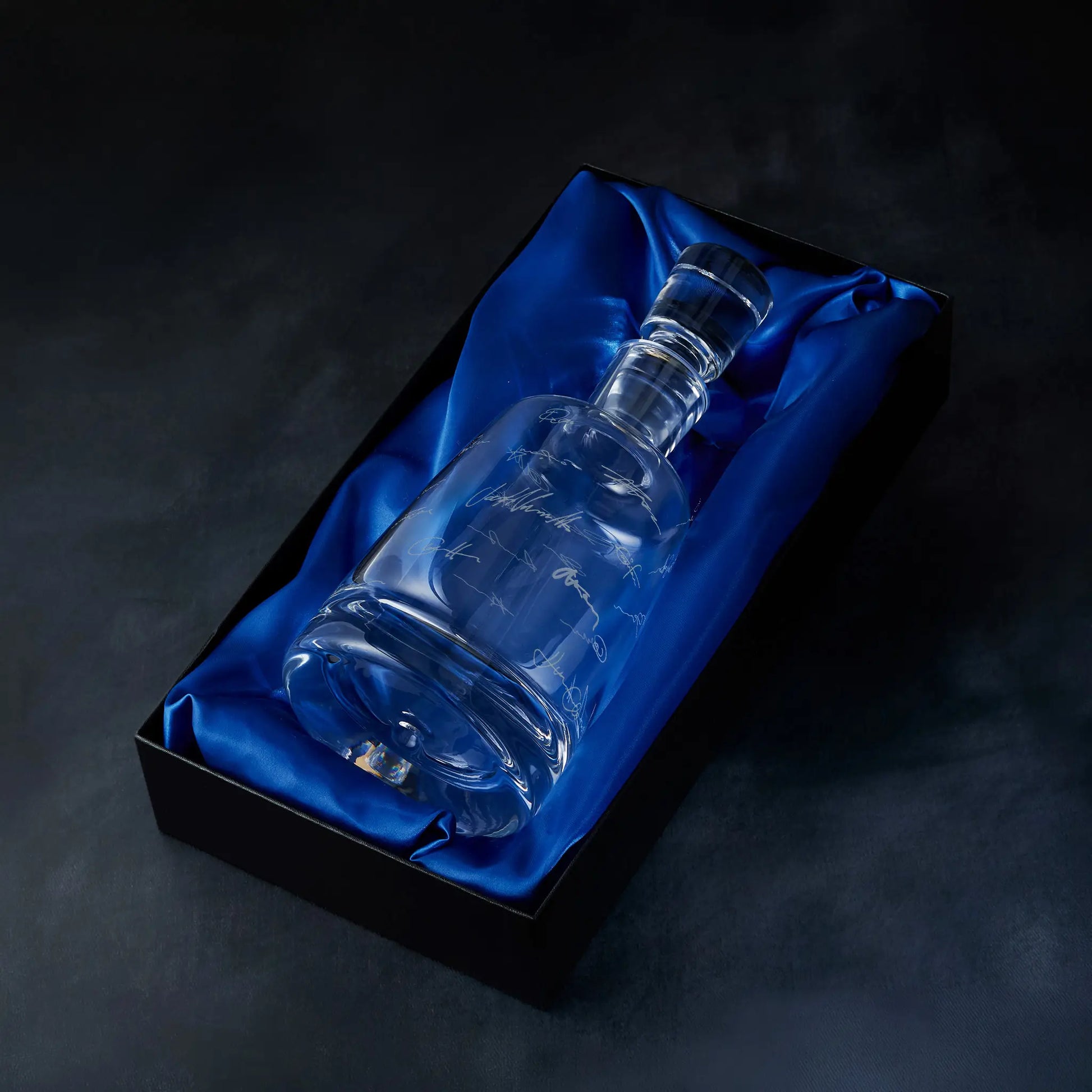 Engraved handritten signatures decanter presented in a satin-lined gift box, photographed on deep blue background