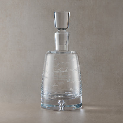 Engraved decanter with wraparound handwritten signatures on a beige background