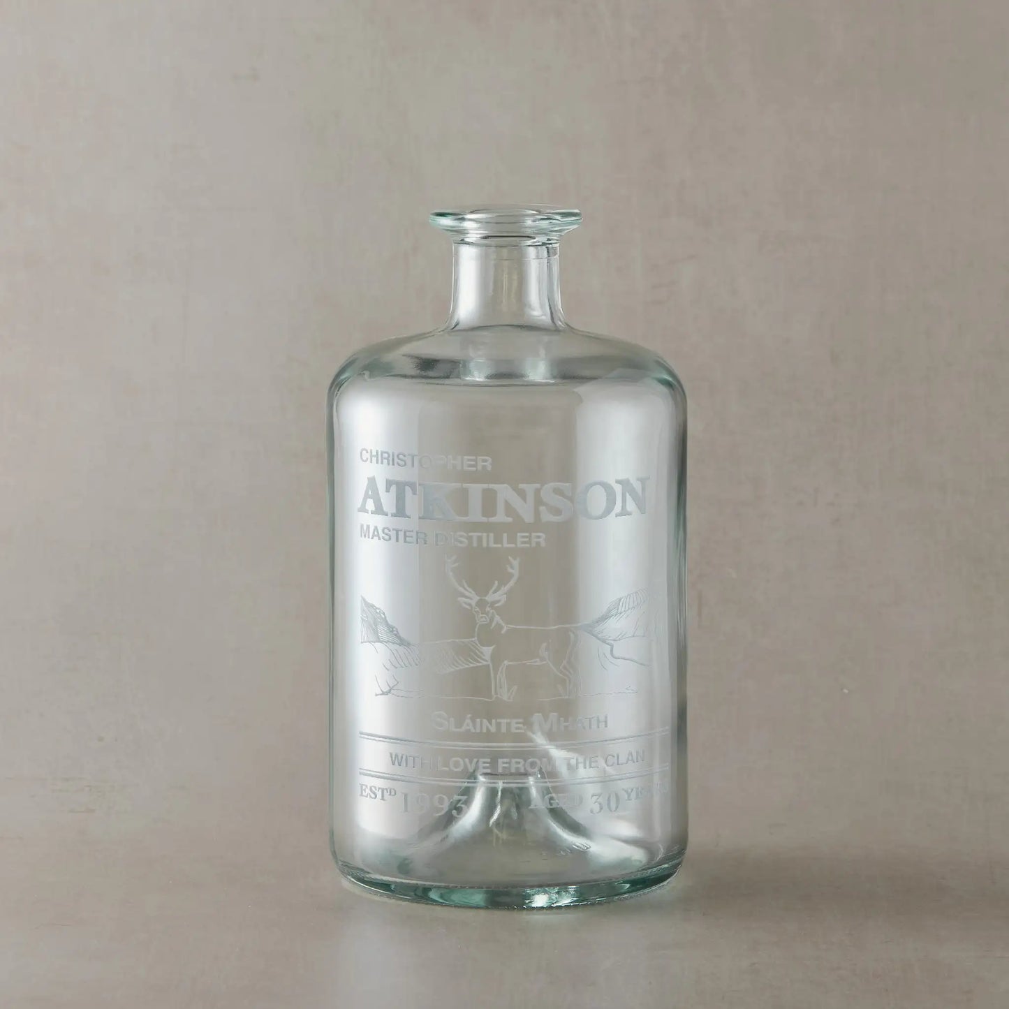 Personalised decanter bottle engraved with a highland stag set against scottish mountains with inscription
