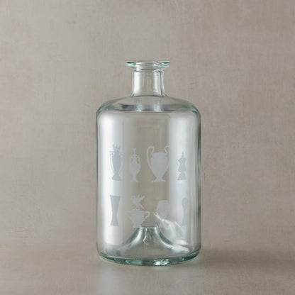 Apothecary-style glass decanter engraved with eight trophy silhouettes and a Liverbird motif, photographed on a beige background