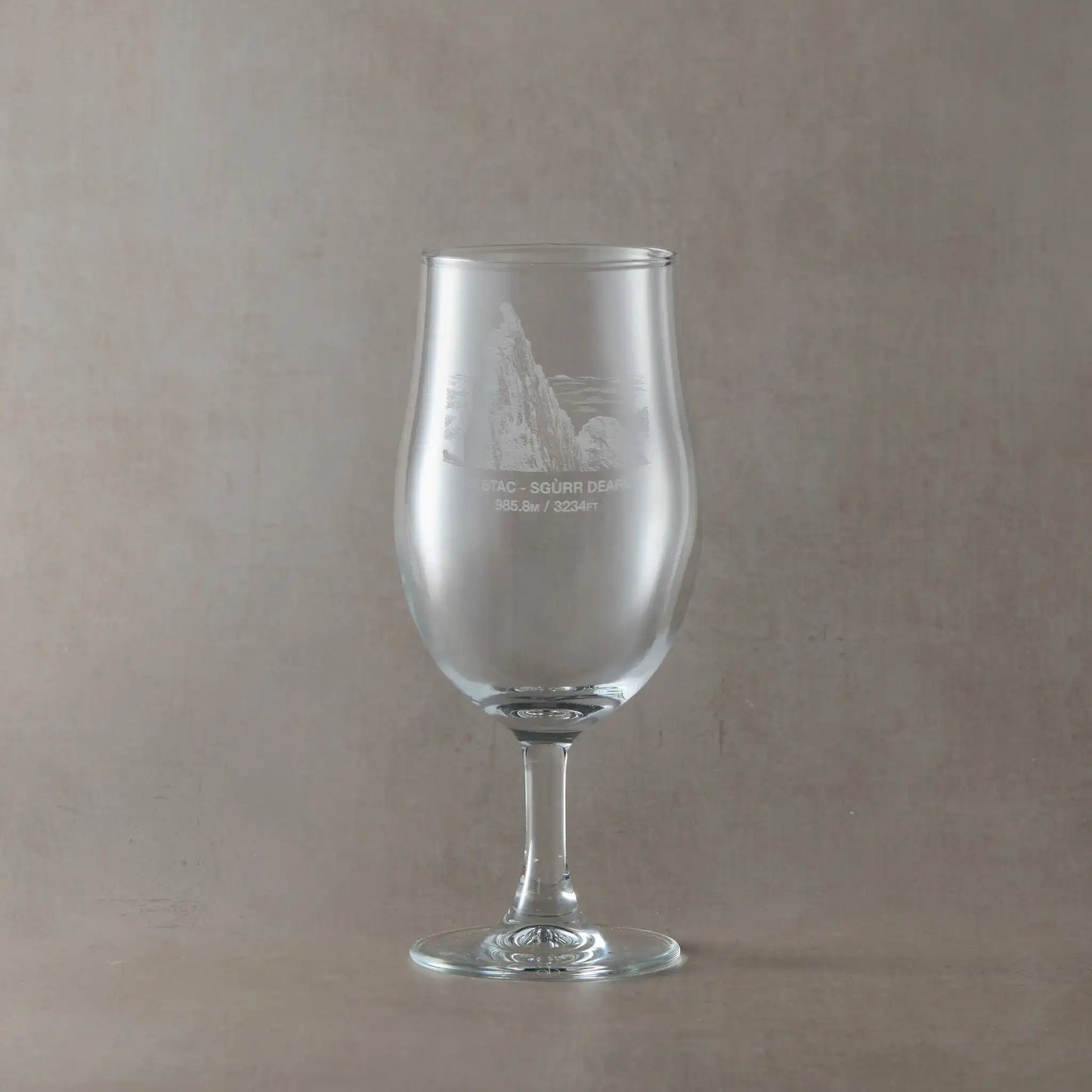 Stemmed Pint glass engraved with the Inaccessible Pinnacle, Sgurr Dearg, shown on a beige background