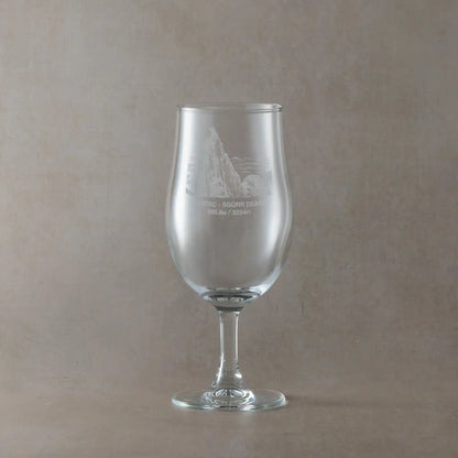 Stemmed Pint glass engraved with the Inaccessible Pinnacle, Sgurr Dearg, shown on a beige background