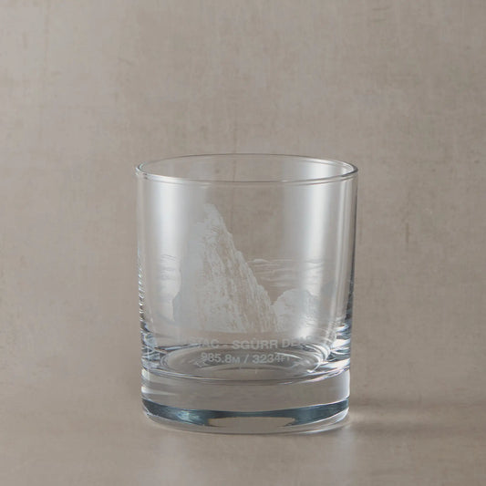 Whisky tumbler engraved with Sgurr Dearg and the Inaccessible Pinnacle, photographed on a beige surface