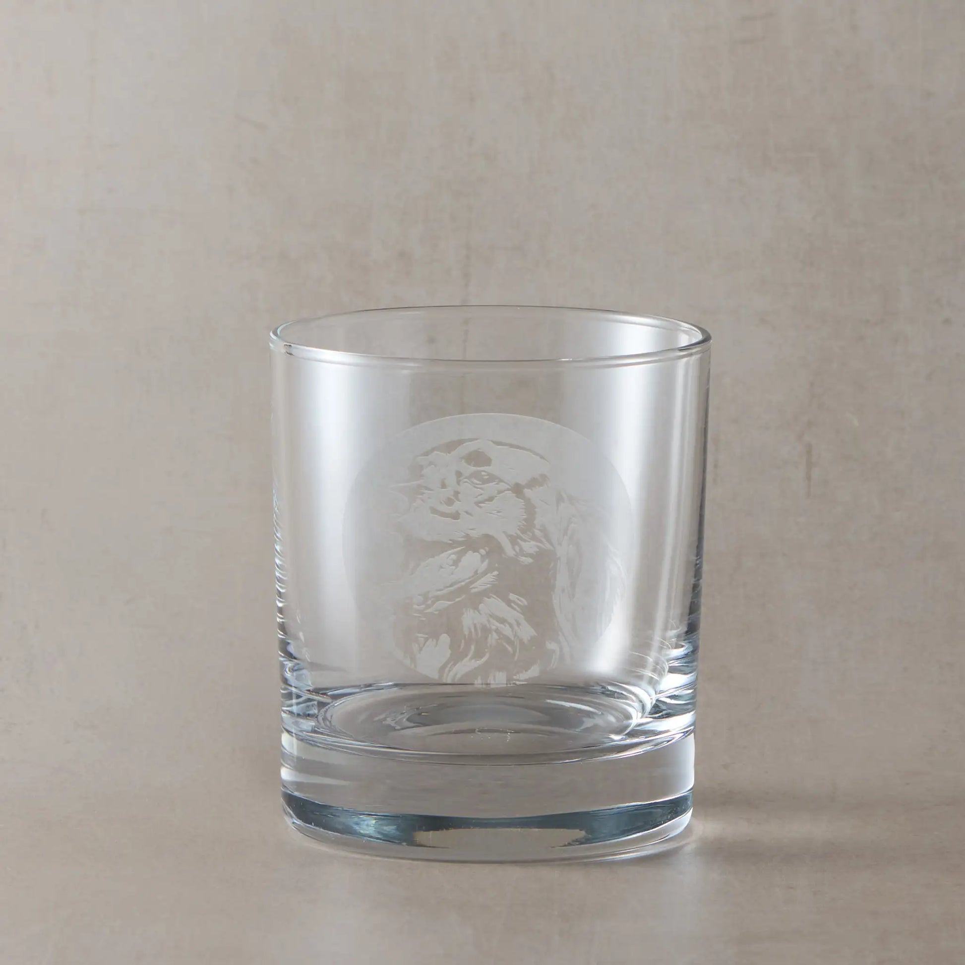 Whisky glass with engraved Red Setter design on a beige background