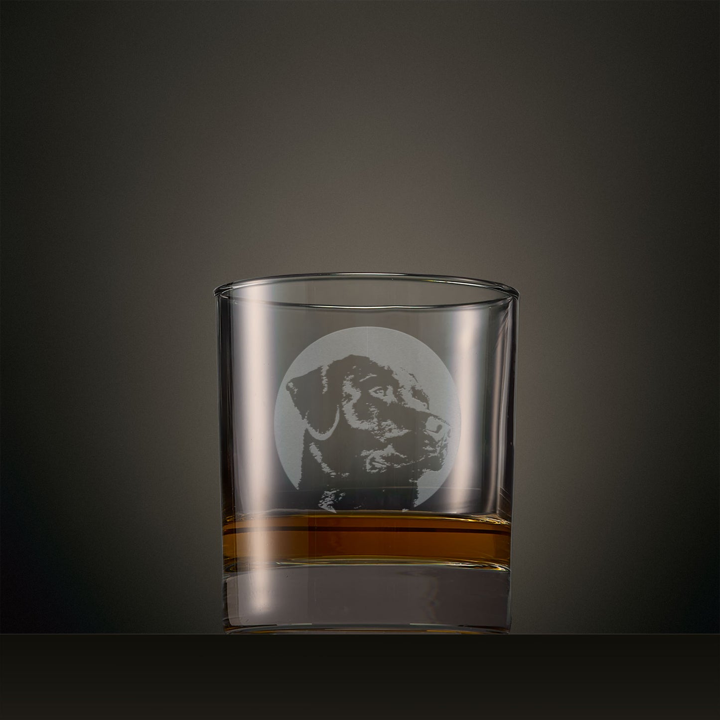 Engraved whisky glass featuring a Labrador portrait set within a circular design, photographed on a studio background