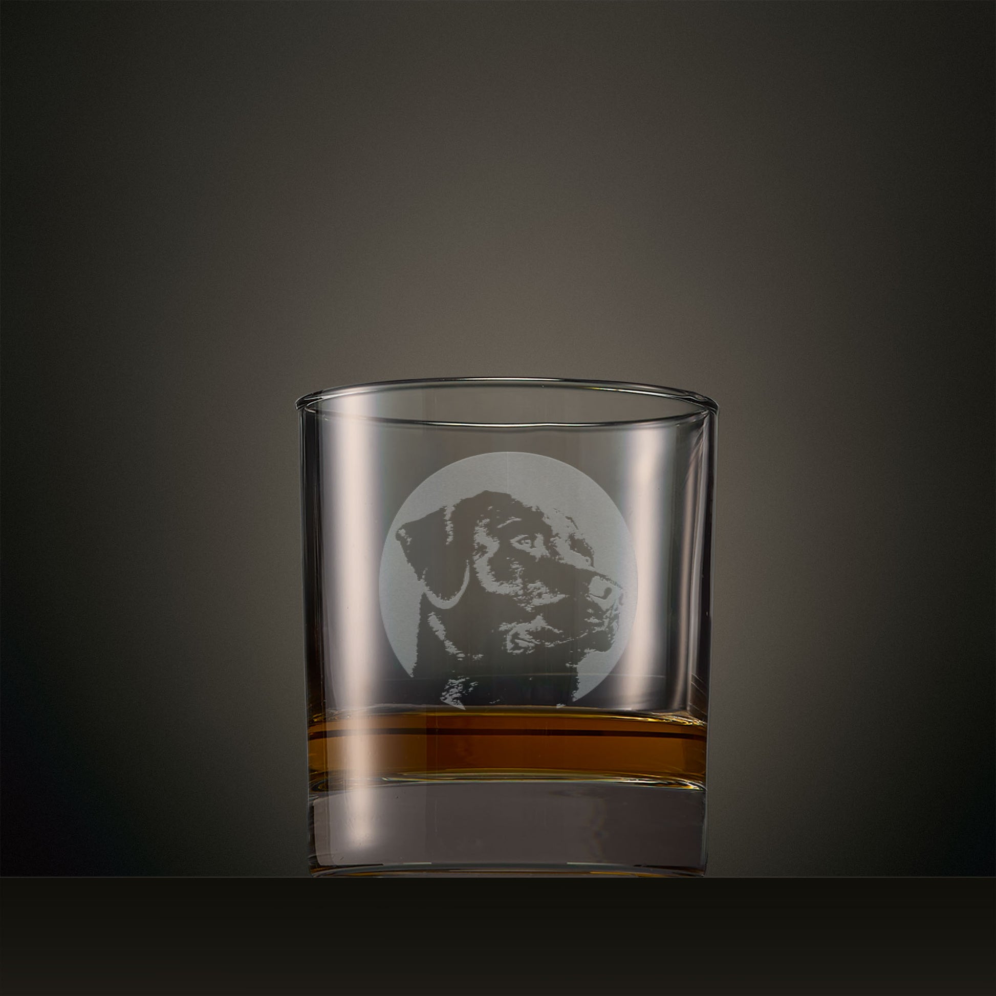 Engraved whisky glass featuring a Labrador portrait set within a circular design, photographed on a studio background