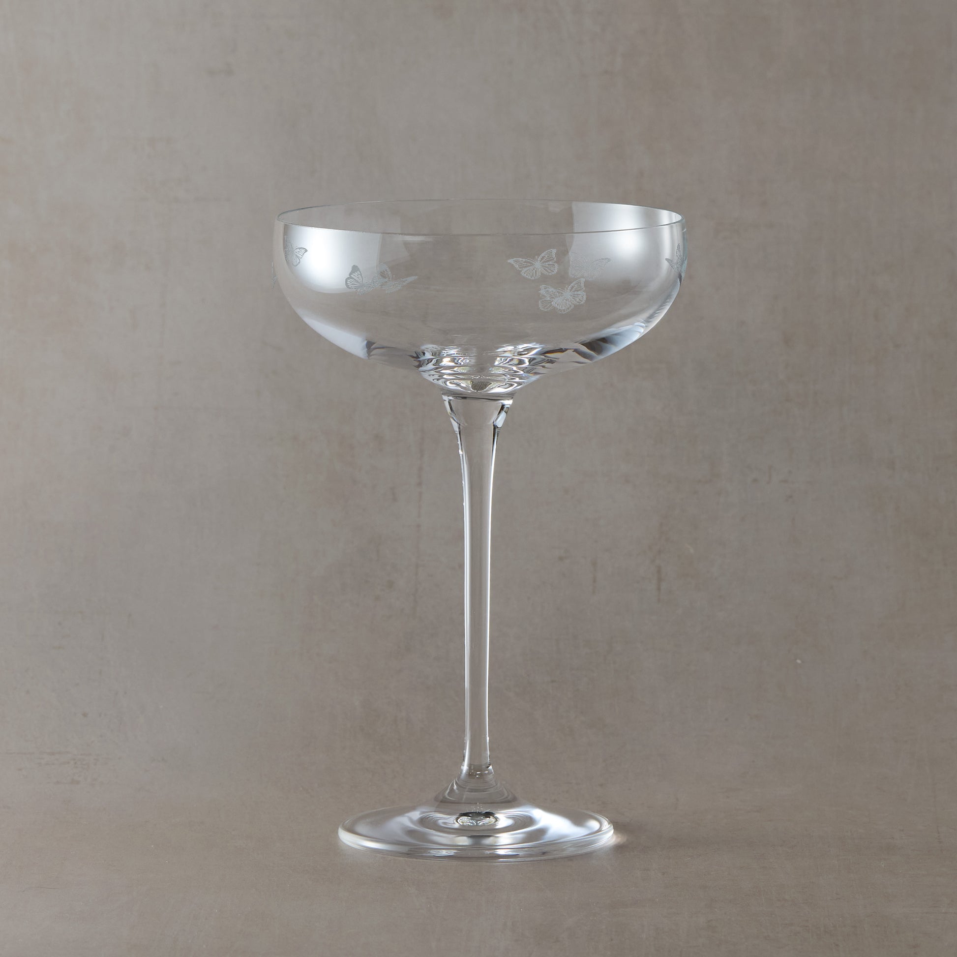 Engraved champagne coupe featuring butterflies in a wrap-around design