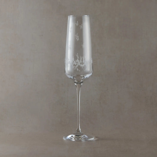 Engraved champagne flute with wraparound floral garland, garden birds and butterflies on a beige background
