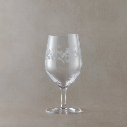 Mineral water glass with flowers, butterflies and garden birds etching on a beige background