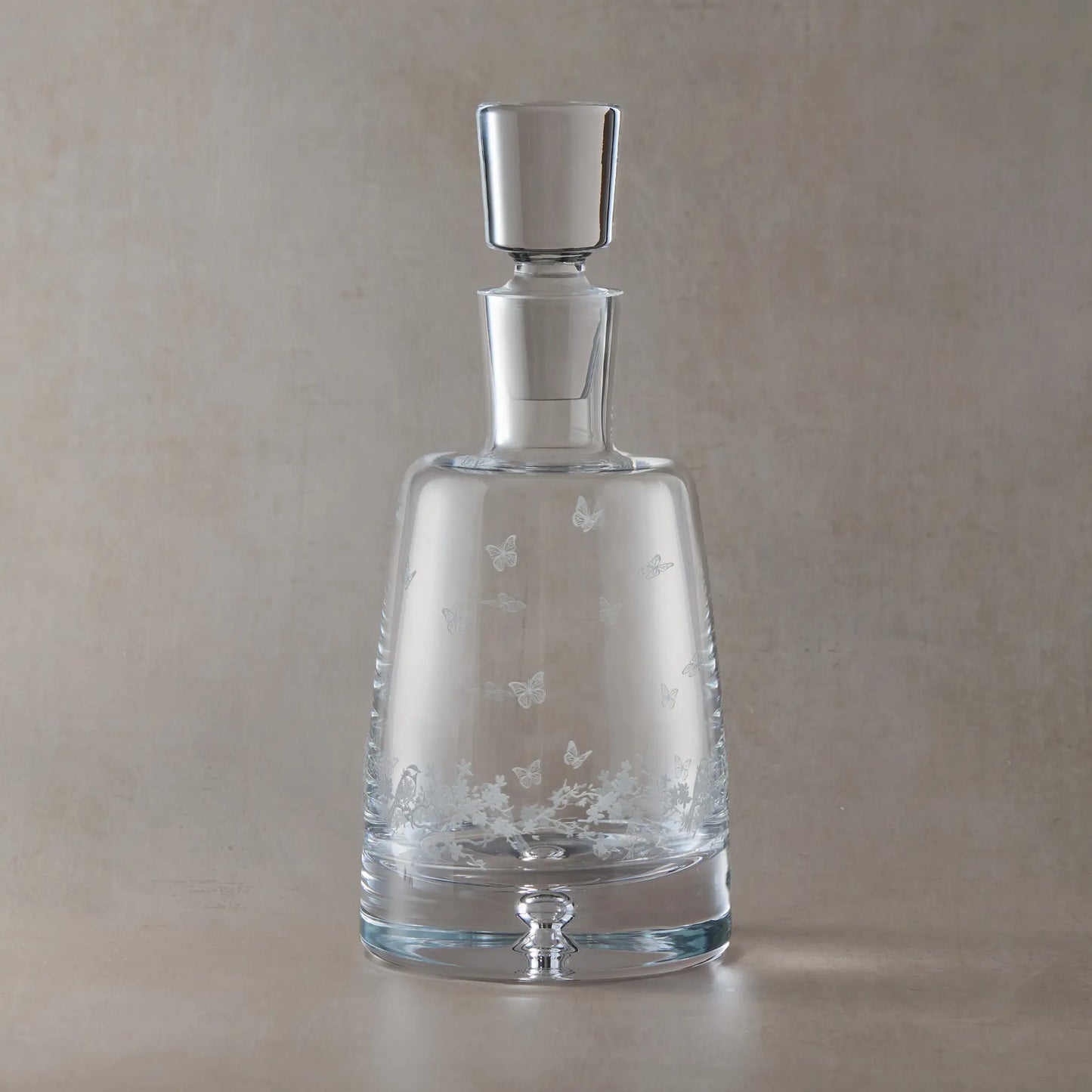 Engraved Le Jardin spirit decanter with wraparound floral garland, garden birds and butterflies on a beige background