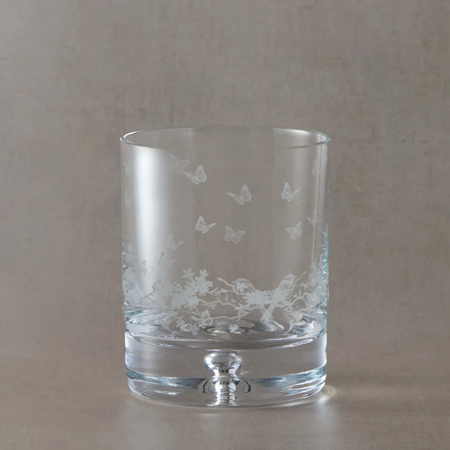 Engraved whisky glass featuring a wraparound floral garland, garden birds and butterflies