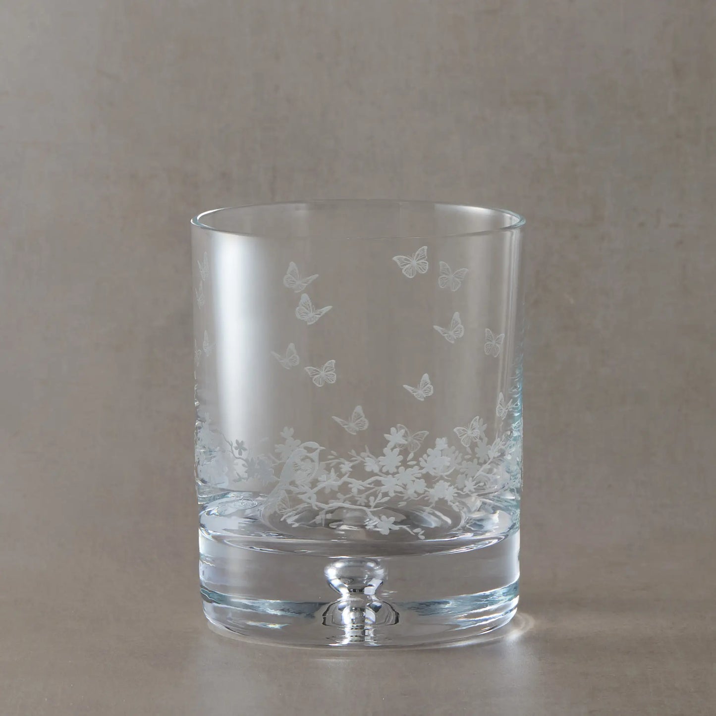 Bubble base whisky glass featuring a floral design, butterflies and garden birds