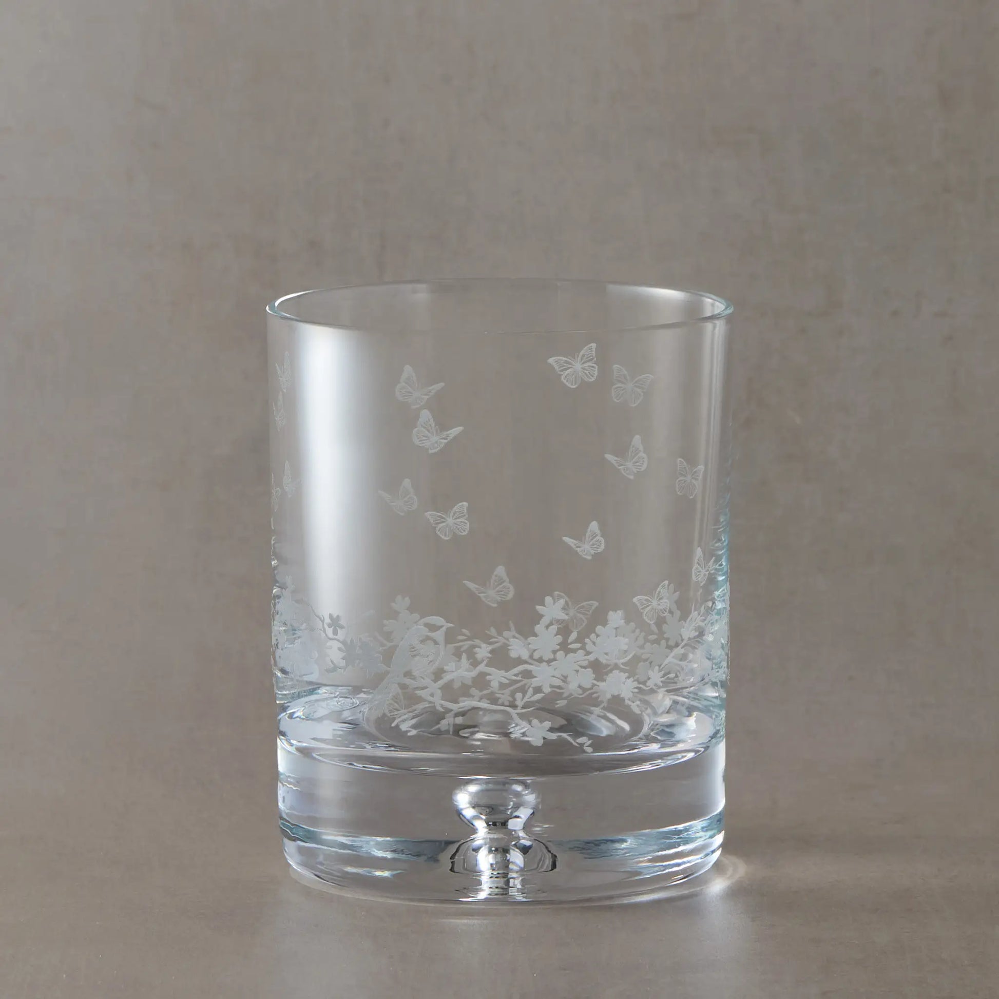 Bubble base whisky glass featuring a floral design, butterflies and garden birds