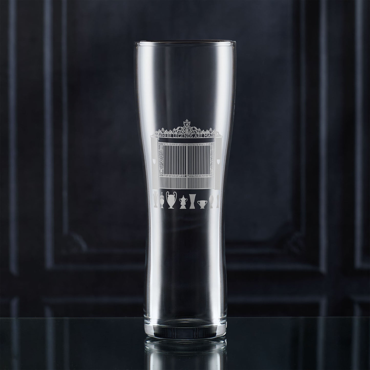 Pint glass with engraved LFC shankly gates and championship trophies design on a dark background