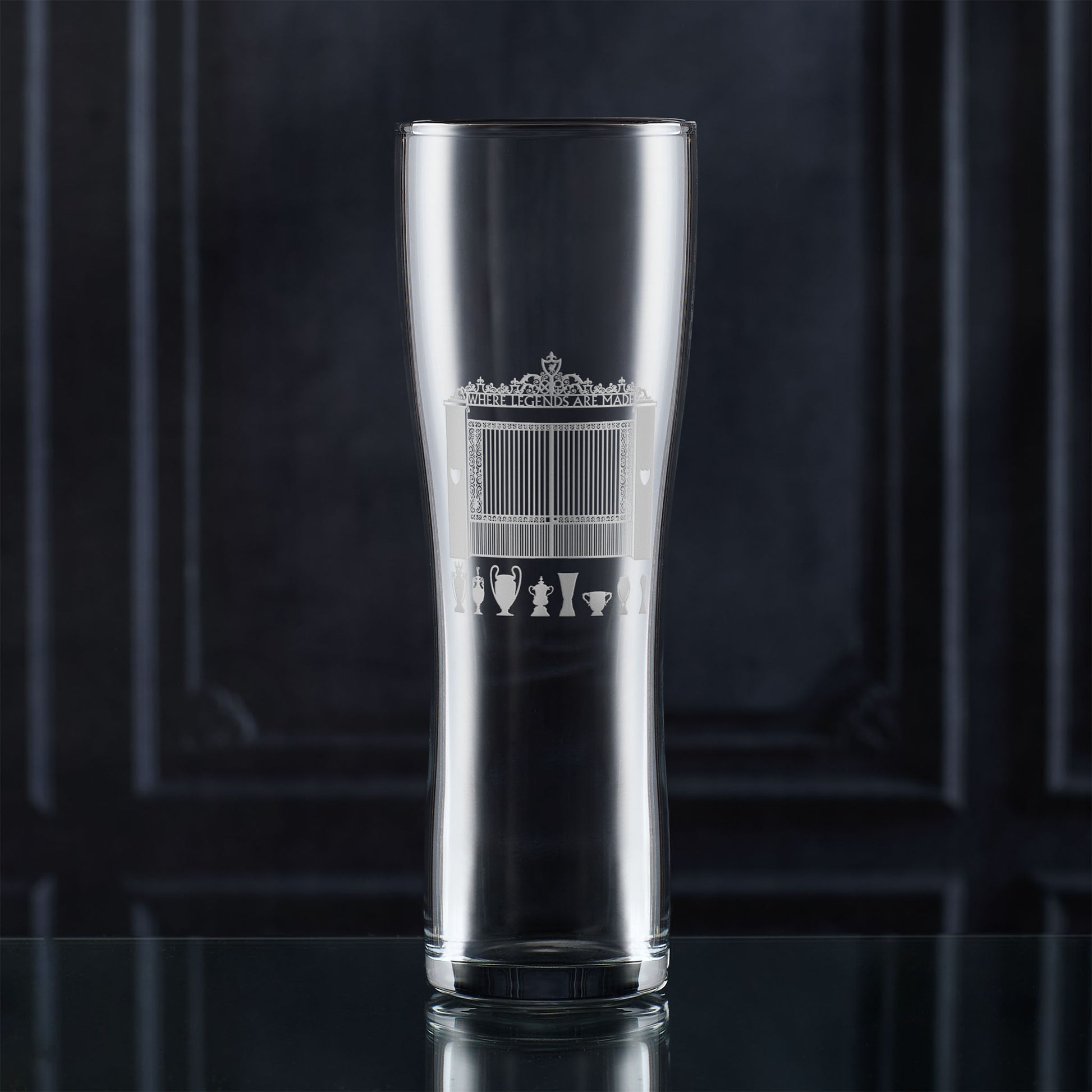Pint glass with engraved LFC shankly gates and championship trophies design on a dark background