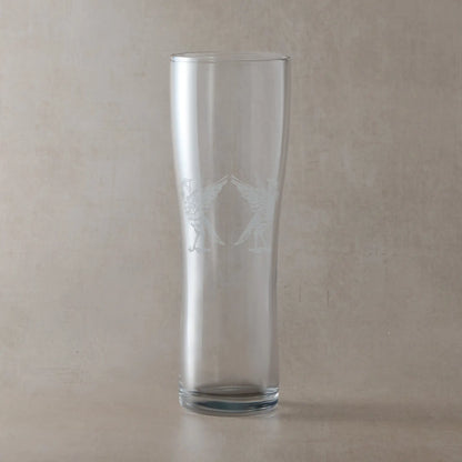 Tall pint glass with an engraving of two Liverbirds on a beige background