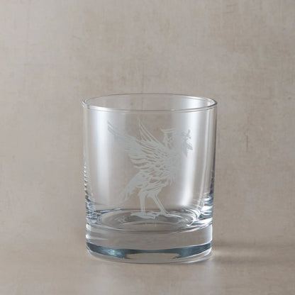 Whisky glass engraved with a Liverbird facing right photographed on a beige background