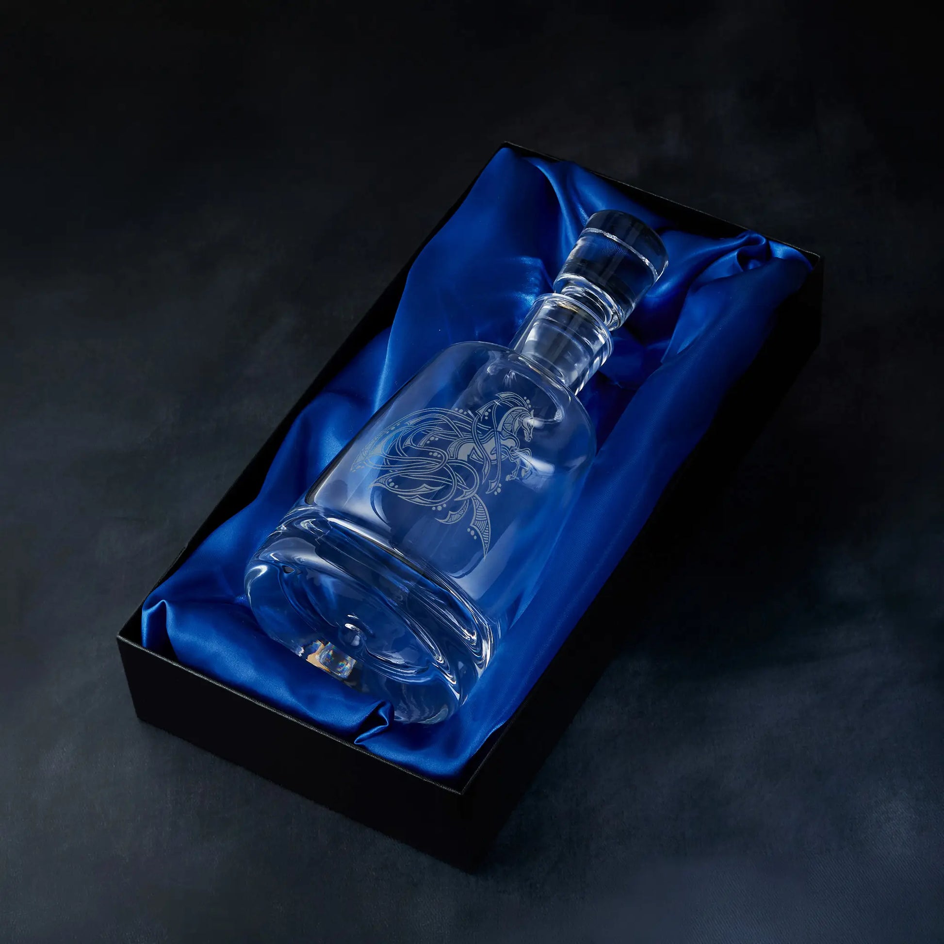 Engraved horse design spirit decanter presented in a satin-lined gift box, photographed against a deep blue background