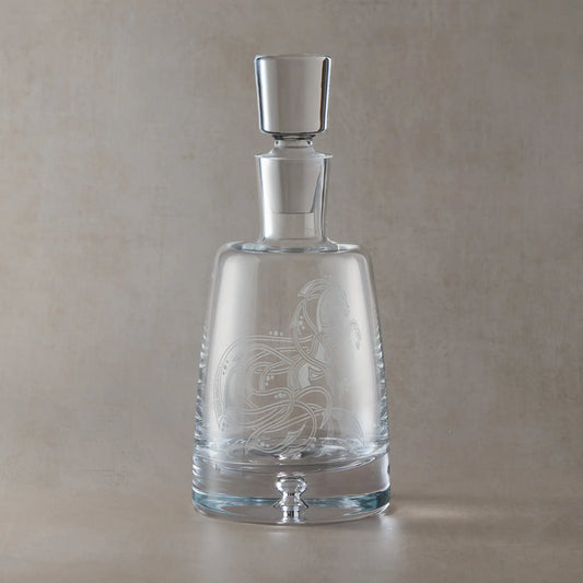 Handmade engraved spirit decanter featuring an anamorphic Celtic horse design, sandblasted onto clear glass against a neutral beige studio background