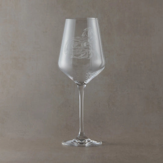 Wine glass engraved with intricate knotwork horse design on a pale background