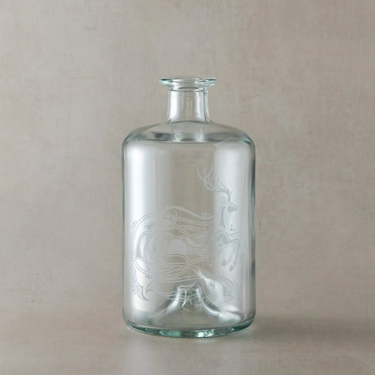 Engraved apothecary style decanter with intricate celtic knotwork stag design on a light  background