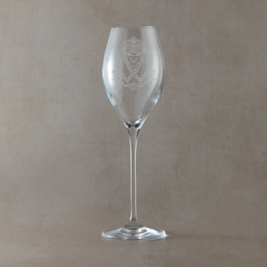 Atelier prosecco glass engraved with crowned Luckenbooth, thistles, and stag design, shown on beige background