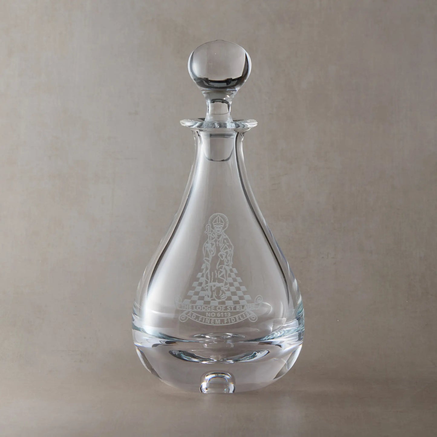 Engraved wine decanter featuring a masonic lodge logo, with ground glass spherical stopper