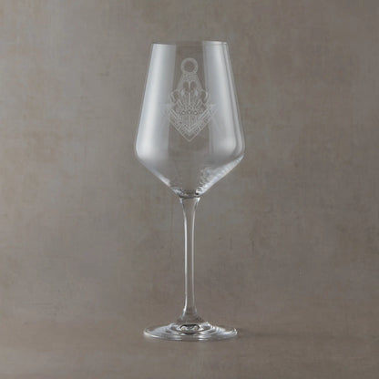Clear wine glass engraved with a Masonic lodge crest design, shown as an example layout for custom lodge or personal engraving, set on a neutral beige studio background