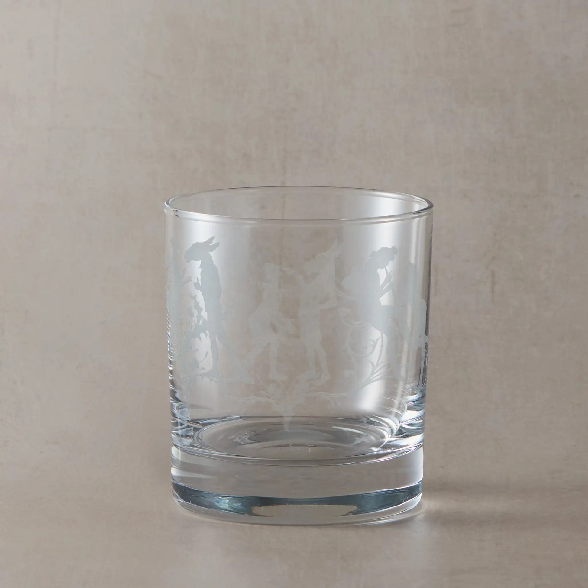 Shakespeare whisky glass with engraved Midsummer Nights Dream design on a beige background
