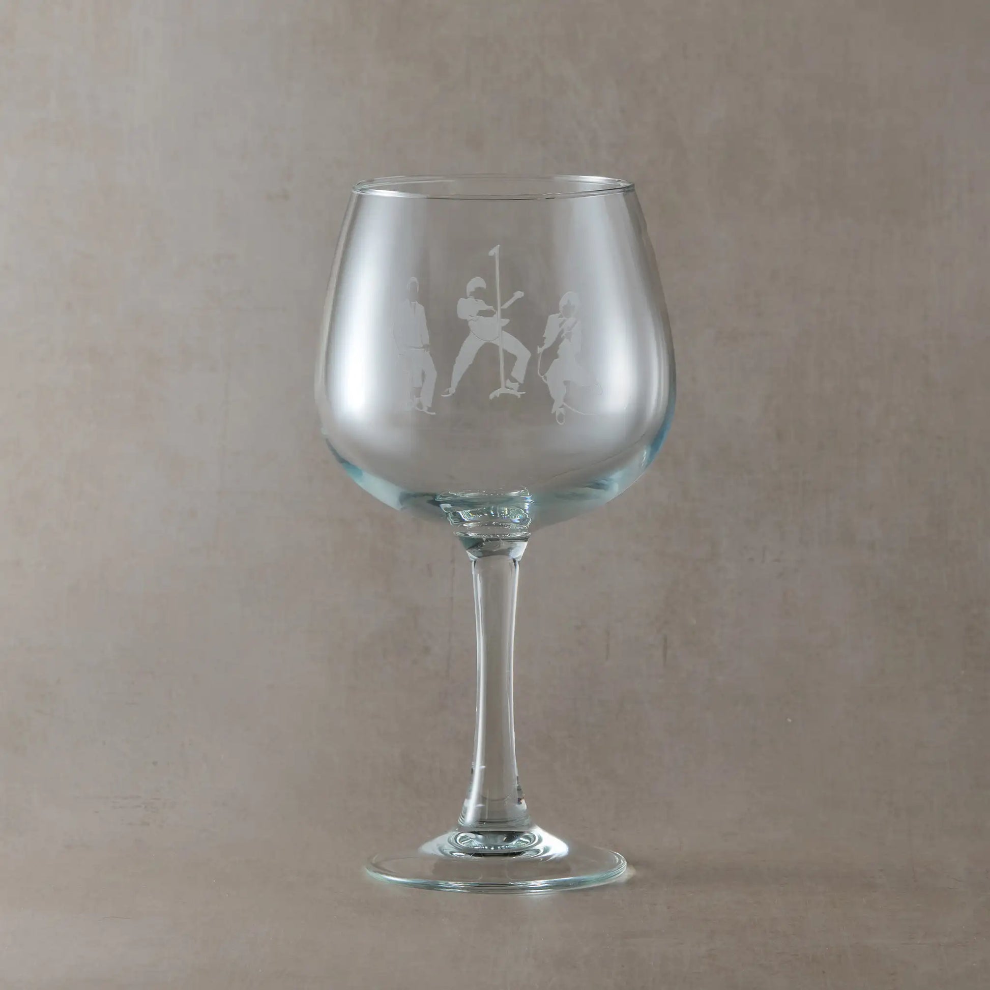 Gin glass engraved with the The Jam band members silhouettes, on a beige background