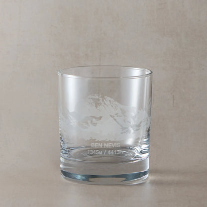 Whisky glass engraved with Ben Nevis, Scafell Pike and Snowdon, photographed on a studio background