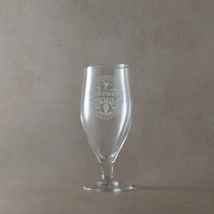 Stemmed chalice beer glass with engraved Northern Soul design on a beige background