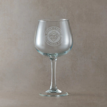 Gin glass engraved with a Wigan Casino badge and the words Keep the faith, heart and soul, on a beige background
