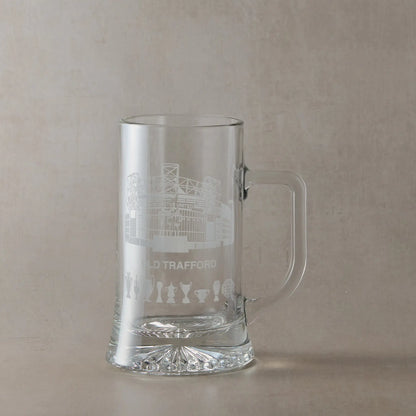 Hand-engraved line-art interpretation of Old Trafford on a pint tankard, with space for personalised text or scoreline.